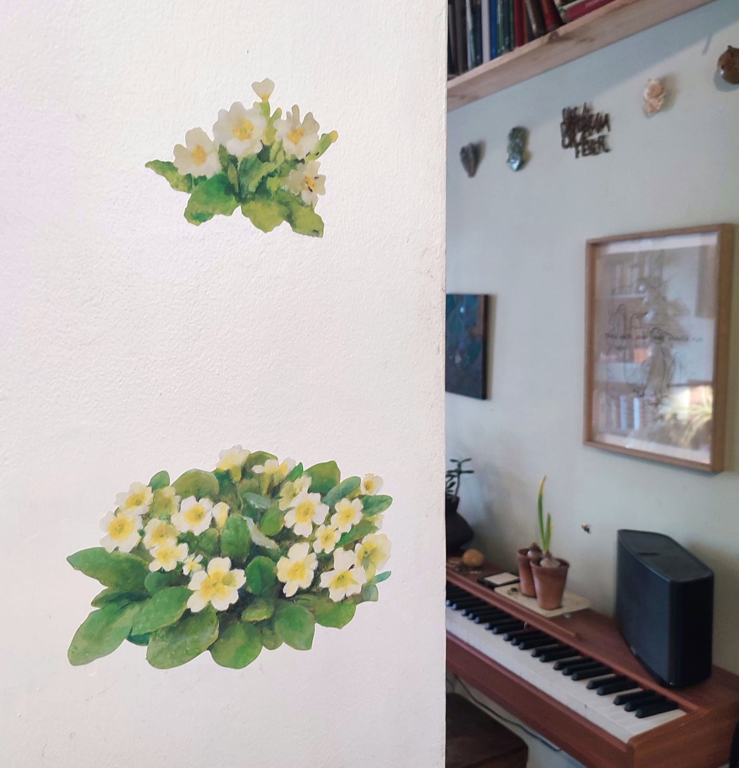 primrose wall decal on a plain wall next to a room with a piano and decor.