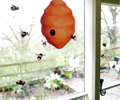 Bee house with small bees on a window with garden view