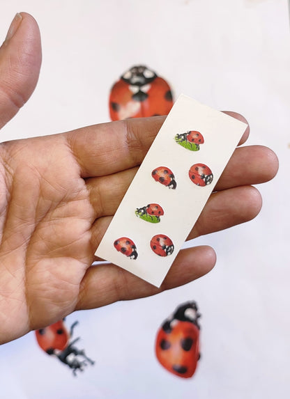 hand holding set of ladybird fabric decals