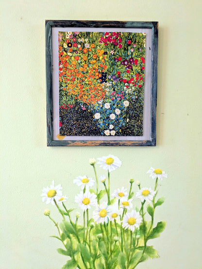 A framed floral art print hangs on a pale yellow wall above a decal of white daisies with yellow centers and green stems. 